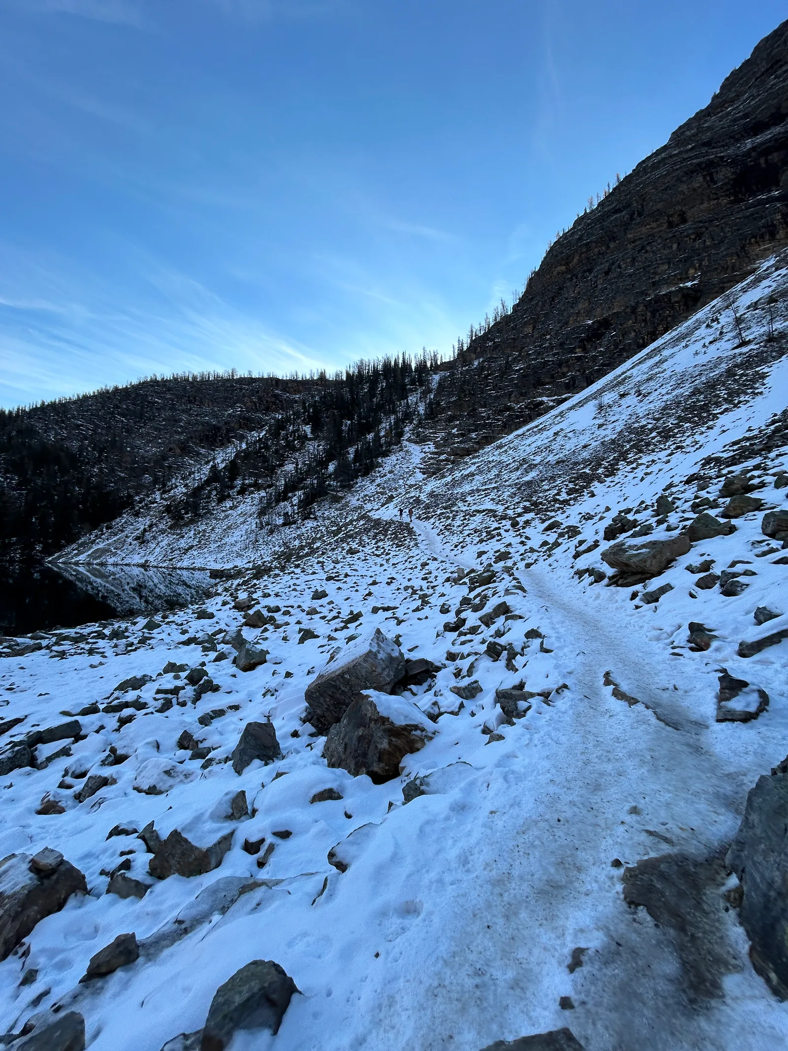 Steep, snow- and ice-covered slope on the Big Beehive approach trail, rock outcrops dusted white
